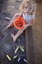 High angle view of girl drawing with chalk on tile