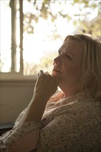 Close up of older woman resting chin in hand