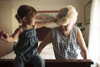 Grandmother and granddaughter playing on bed