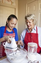 Grandmother and granddaughter baking in kitchen