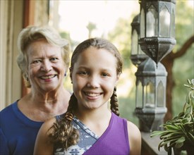 Grandmother and granddaughter smiling on porch