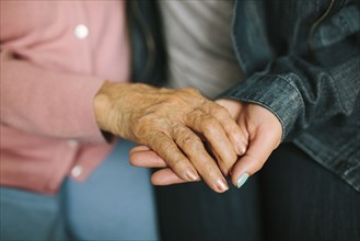Close up of grandmother and granddaughter holding hands