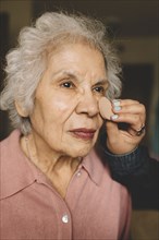 Granddaughter applying makeup on grandmother