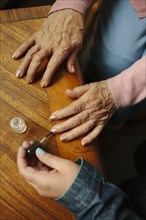 Granddaughter applying painting fingernails of grandmother