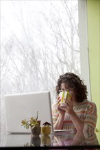 Caucasian businesswoman drinking coffee at desk