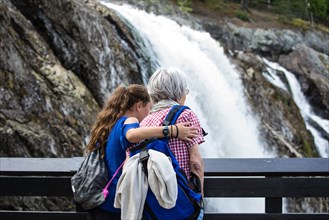 Grandmother and granddaughter admiring waterfall