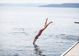 Caucasian girl diving into lake