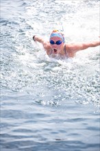 Caucasian swimmer gasping for air in lake