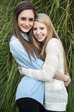 Smiling Caucasian teenage girls hugging
