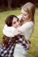 Caucasian teenage girls hugging in backyard