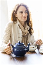 Caucasian woman drinking tea at table
