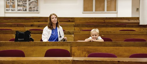 Student doctor and son sitting in college classroom
