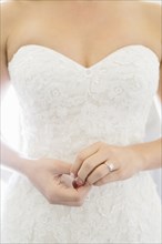 Close up of bride wearing wedding dress and engagement ring