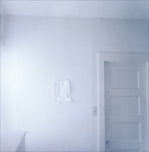 Wrinkled paper on empty white wall