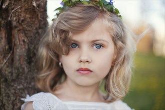 Serious Caucasian girl near tree