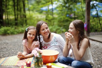Caucasian mother and daughters sitting outdoors