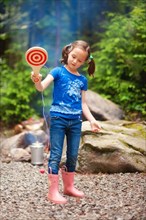 Caucasian girl playing with toy in forest