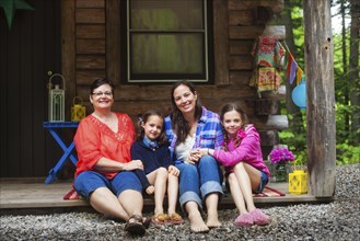Three generations of Caucasian women smiling on cabin porch