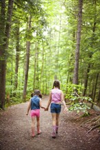 Caucasian sisters walking in forest