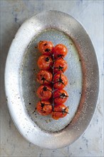 Plate of roast cherry tomatoes on vine