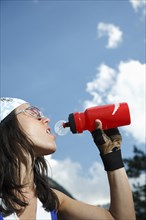 Caucasian woman drinking water bottle outdoors