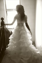Rear view of bride walking down staircase