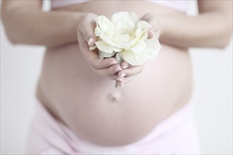 Pregnant Caucasian woman holding flower