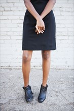 Stylish Black woman wearing dress and boots