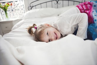 Smiling girl playing on bed