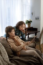 Hispanic mother and daughter admiring picture frame