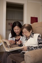 Asian mother and daughter looking at photo album