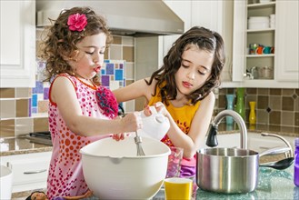 Sisters baking in kitchen