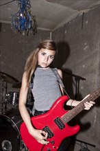 Girl playing guitar in rock band