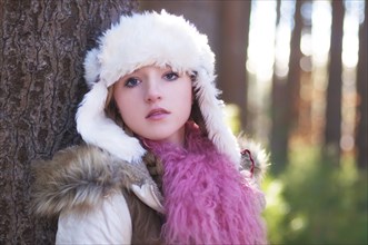 Caucasian teenage girl wearing fuzzy hat outdoors