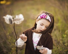 Caucasian girl examining plants outdoors