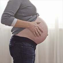 Pregnant Caucasian woman caressing stomach