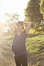 Pregnant Caucasian woman exercising outdoors