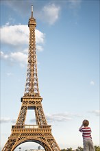Caucasian boy admiring Eiffel Tower under blue sky