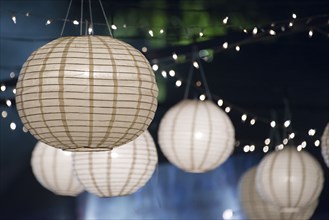 Close up of paper lanterns and string lights at night