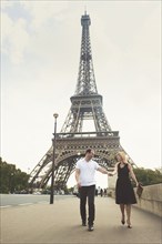 Caucasian couple walking near Eiffel Tower