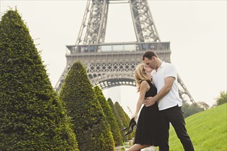 Caucasian couple kissing near Eiffel Tower