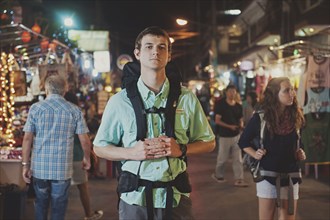 Caucasian tourist standing in market at night