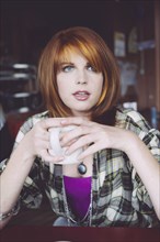 Caucasian woman drinking coffee in cafe