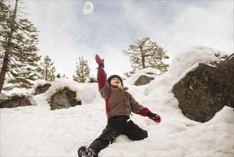 Boy throwing snowball overhead