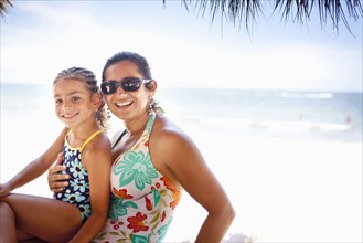 Smiling mother and daughter enjoying tropical beach