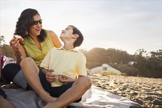 Mother and son enjoying picnic on beach