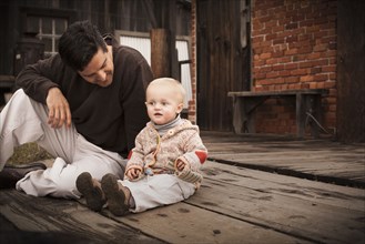Caucasian father sitting on floor with son
