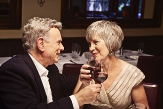 Couple toasting with red wine in restaurant