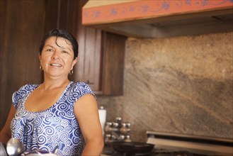 Hispanic woman standing in kitchen