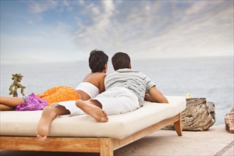 Hispanic couple relaxing near ocean